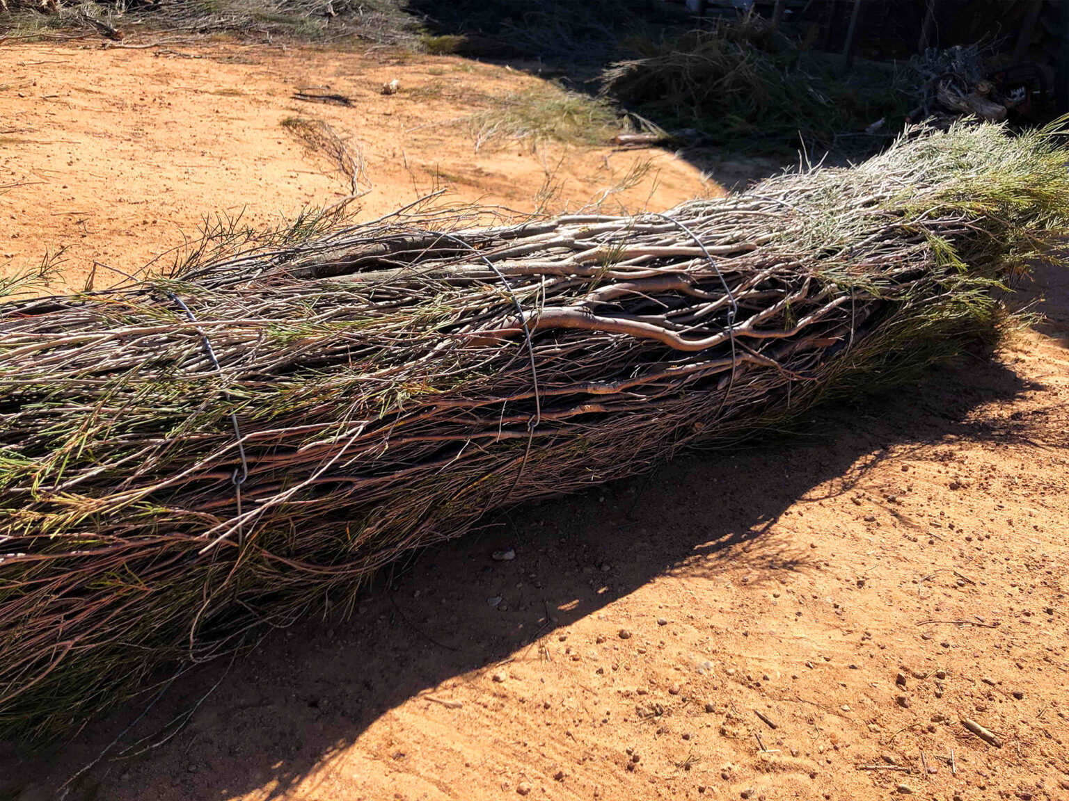 Tightly rolled brushwood log sitting on a river bed ready for installation